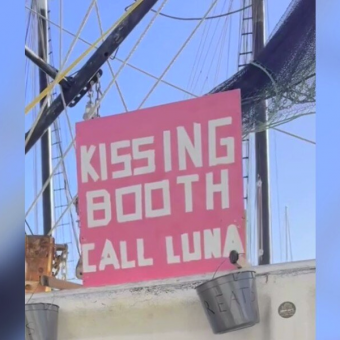 Tourists Spot ‘Kissing Booth’ Sign On Docked Boat — Then A Sweet Dog Pops Into View